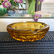 Load image into Gallery viewer, Vintage &quot;Fairfield&quot; amber ashtray. This piece has a beautiful sculptural pattern. Produced by Anchor Hocking between 1972 - 1977. A great piece that could be used in multiple ways, candy, catchall, bath vanity, decor....whatever your imagination can dream up or smok&#39;em if you&#39;ve got&#39;em!  In used vintage condition, free from chips/cracks. Wear on the bottom.  Measures 6-1/4 x 1 5/8 inches
