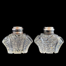 Load image into Gallery viewer, Enhance your tablescape with sparkling vintage brilliant fine cut crystal fan-shaped salt and peppers shakers topped with sterling silver lids inlaid with mother-of-pearl....stunning!

The crystal is in excellent condition, no chips. The sterling silver lids show age related wear. Marked Sterling 925 with hallmark.

Measures 2 x 4 1/2 inches
