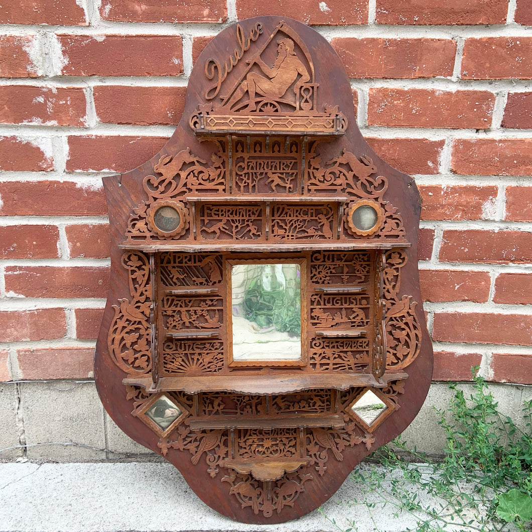 Incredible primitive antique Father Time handmade wood scroll saw wall hung shelf depicting the months of the year with scenes of figures, flora and fauna including birds, rabbits and flowers depicting an activity appropriate to the month, topped with a lounging Father Time with sycthe and hourglass. There are a total of 10 shelves which are notched together and removable, in addition there are 4 mirrors.  In as found condition with a corder of the backboard damaged.