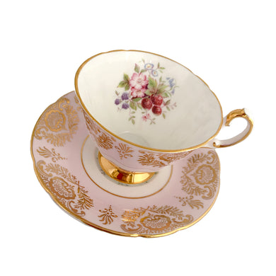 Stunning vintage teacup and saucer decorated with a pale pink exterior with a gold gilt pattern of a shells and leaves along with a white interior with a sweet field berry motif on the inside of the teacup and middle of the saucer. Produced by The Paragon China Company, England, circa 1950. In excellent condition, free from chips/cracks/repairs. Marked on the bottom with single warrant stamp.
