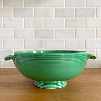 Fiesta medium green scroll handled 1.5 quart casserole dish. Crafted by Homer Laughlin Company, 1960s. The classic style and durability of this restaurant ware can't be beat!

In good condition, free from chips/cracks, some manufacturer's glaze pops in the bottom of the bowl. Maker's mark on the bottom.

Measures 7 3/4 x 3 1/2 inches (not incl. handles)