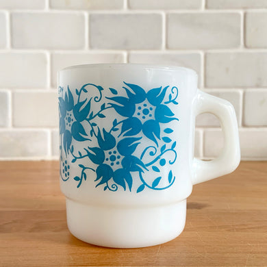 Highly collectible Fire-King milk glass mug printed with graphic ;turquoise blue flowers, D-handle. Crafted by Anchor Hocking, USA, circa 1970s. A must-have for any graphic mug collection!

In excellent condition, no chips, cracks or repairs. Colours are vibrant and shiny.

Measures 3 x 3 1/2 inches
