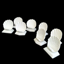 Load image into Gallery viewer, Angled view of eight white glazed ceramic Fitz &amp; Floyd Oceana clam shell place card holders displaying the front fan-shaped shells
