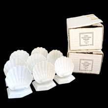 Load image into Gallery viewer, Front view of eight glazed white ceramic clam shell place card holders from Fitz &amp; Floyd's Oceana collection, arranged beside their original boxes
