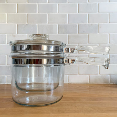 Vintage Flameware clear glass double boiler no. 6283-U1 1/2 QT with glass lid 6283-C C-18. Crafted by PYREX, USA, between 1936 - 1979. The absolute best way to melt chocolate, make creamy smooth hollandaise sauce or prepare custards!

In excellent condition, no chips. Maker's mark on each piece.

Measures 12 x 6 1/2 x 7 1/2 inches (incl. handle)