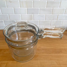 Load image into Gallery viewer, Vintage Flameware clear glass double boiler no. 6283-U1 1/2 QT with glass lid 6283-C C-18. Crafted by PYREX, USA, between 1936 - 1979. The absolute best way to melt chocolate, make creamy smooth hollandaise sauce or prepare custards!

In excellent condition, no chips. Maker&#39;s mark on each piece.

Measures 12 x 6 1/2 x 7 1/2 inches (incl. handle)
