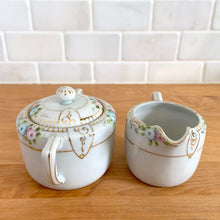 Load image into Gallery viewer, Side view of vintage Nippon Morimura Brothers lidded sugar bowl and creamer set with hand-painted florals and gold accents
