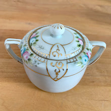 Load image into Gallery viewer, Close-up of vintage Nippon lidded sugar bowl with hand-painted pink and blue roses, gold scrollwork cartouche, and knob finial lid
