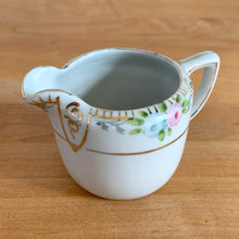 Load image into Gallery viewer, Side detail of vintage Nippon porcelain creamer showing hand-painted floral spray with pink roses, blue flowers, and gold trim
