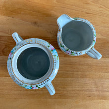 Load image into Gallery viewer, Overhead view of open vintage Nippon sugar bowl and creamer showing hand-painted floral border and gold detailing on interior rim
