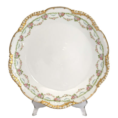 Vintage round porcelain serving plate decorated with swags of flowers in shades of pink, green, blue and white, surrounded by a gold gilt scalloped rim which alternates between smooth and saw tooth. Crafted by Württembergische Porzellanmanufaktur Bauer & Pfeiffer (1904 until 1918) or Württembergische Porzellanmanufaktur AG (1918 until 1934), Germany. A lovely piece that's sure to become a treasured family heirloom!  In excellent condition, no chips/cracks/repairs.  Measures 13 inches
