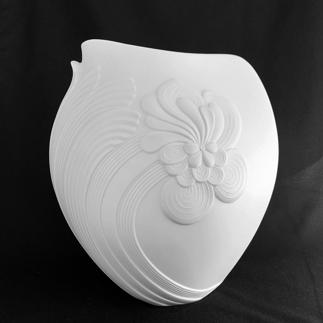 Vintage white bisque flower vase, 0327, featuring an embossed Art Nouveau flower and leaf plume with smooth rim. Designed by M. Frey for Kaiser, Germany, 1980s. This delicate ovoid shaped vase will look stunning in any setting!

In excellent condition, no chips/cracks/repairs. Maker's mark on bottom.

Measures 8 1/4 x 7 x 8 7/8 inches