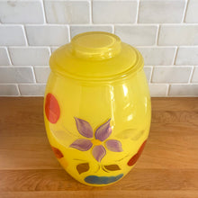 Load image into Gallery viewer, Vintage mid-century yellow glass lidded canister or cookie jar hand painted with flowers and fruits. Crafted by Bartlett Collins, 1960s. A nice sized and pretty jar to store cookies or dry goods.

In good vintage condition, no chips, age-related wear to the gold.

Measures 7 x 9 1/2 inches
