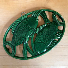 Load image into Gallery viewer, Forest green enameled cast iron trivet with fish design, angled view showing texture and enamel finish
