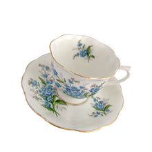 Load image into Gallery viewer, Vintage Avon shaped Forget-Me-Not bone china teacup and saucer, features a scalloped edge with hand painted blue flowers and gold gilt rim. Royal Albert, England, 1950s.  In excellent condition, free from chips, cracks and repairs. Makers marks present.  Teacup measures 3 1/4 x 2 3/4 inches | Saucer measures 5 1/2 inches
