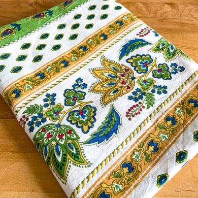 Vintage round French provençal white tablecloth featuring yellow, red, green and blue florals. In excellent vintage condition, free from stains/tears. Measures 69 x 74 inches