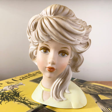 This rare highly collectible vintage mid-century ceramic blonde Ghost Girl teen lady head vase (E-6210) boasts golden locks swept to one side, a yellow shirt, and a painted face in muted tones. Crafted by Inarco, Japan, circa 1950s. The ceramic vase is in excellent condition, free from chips/cracks/repairs. Marked on the bottom with original sticker. Missing earrings. Find replacements on eBay/Etsy. Measures 4 1/4 x 3 3/4 x 6 3/4 inches 