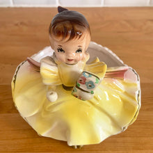 Load image into Gallery viewer, Adorable vintage mid-century era girl in a yellow dress ceramic planter 502. Crafted by Rubens Originals, Japan, 1950s. Use for tiny plants or repurpose to hold accessories.

In as found vintage condition, bow is chipped at the back, no cracks/repairs.

Measures 4 1/2 x 4 x 4 1/2 inches
