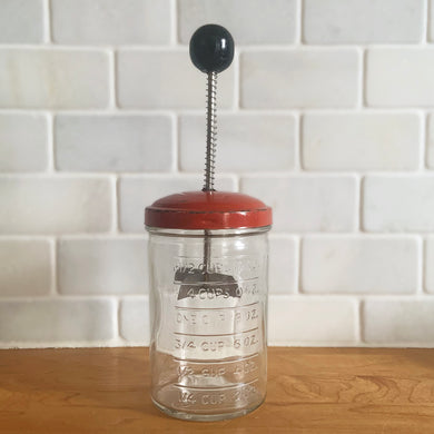 My grandmother used to have one of these handy kitchen choppers. It has a glass measuring jar, red metal lid and spring loaded metal blade and black wood knob handle. Produced by Androck, Canada, circa 1950s. This versatile vintage kitchen accessory can be used to chop just about anything including garlic, onions, small fruits, and eggs and your hands are safe from being chopped too!

In good vintage condition, no chips in the glass, wear to the paint on the lid.

Measures 3 x 9 1/4 inches
