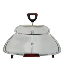 Load image into Gallery viewer, Glo-Hill Gourmates chrome tidbit tray, three-quarter front view showing the two-tier square chrome trays, central chrome post, and amber Bakelite top handle
