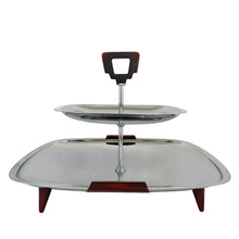Load image into Gallery viewer, Glo-Hill Gourmates chrome tidbit tray, side profile view showing the two stacked square chrome tiers, central post with chrome detailing, and amber Bakelite handle and feet
