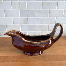 Load image into Gallery viewer, Vintage glossy brown drip glazed ceramic handled gravy boat. Crafted by Hull Pottery, USA, 1960s. A beautiful piece to add to your art pottery tableware collection!

In excellent condition, no chips/cracks/repairs. Maker&#39;s marks.

Measures 10 3/8 x 4 1/4 x 5 5/8 inches
