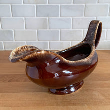 Load image into Gallery viewer, Vintage glossy brown drip glazed ceramic handled gravy boat. Crafted by Hull Pottery, USA, 1960s. A beautiful piece to add to your art pottery tableware collection!

In excellent condition, no chips/cracks/repairs. Maker&#39;s marks.

Measures 10 3/8 x 4 1/4 x 5 5/8 inches
