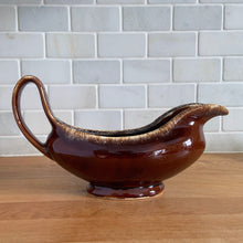 Load image into Gallery viewer, Vintage glossy brown drip glazed ceramic handled gravy boat. Crafted by Hull Pottery, USA, 1960s. A beautiful piece to add to your art pottery tableware collection!

In excellent condition, no chips/cracks/repairs. Maker&#39;s marks.

Measures 10 3/8 x 4 1/4 x 5 5/8 inches
