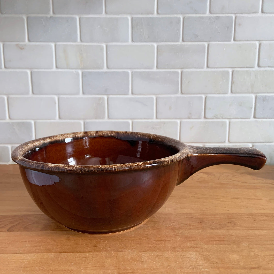 Vintage glossy brown drip glazed ceramic handled soup serving bowl. Crafted by Hull Pottery, USA, 1960s. A beautiful piece to add to your art pottery tableware collection!

In excellent condition, no chips/cracks/repairs. Maker's marks.

Measures 8 1/4 x 3 5/8 (12 x 3 5/8 inches with handle)