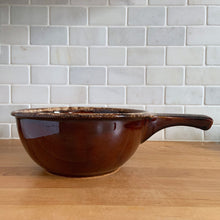 Load image into Gallery viewer, Vintage glossy brown drip glazed ceramic handled soup serving bowl. Crafted by Hull Pottery, USA, 1960s. A beautiful piece to add to your art pottery tableware collection!

In excellent condition, no chips/cracks/repairs. Maker&#39;s marks.

Measures 8 1/4 x 3 5/8 (12 x 3 5/8 inches with handle)
