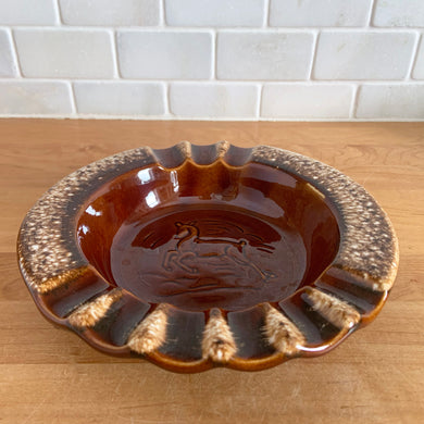 Vintage glossy brown drip glazed ceramic ashtray with impressed horse. Crafted by Hull Pottery, USA, 1960s. A beautiful piece to add to your art pottery collection!

In excellent condition, no chips/cracks/repairs. Maker's marks.

Measures 6 3/8 x 3 1/4 inches