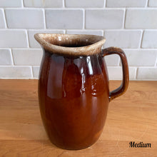 Load image into Gallery viewer, Vintage glossy brown drip glazed ceramic pitcher. Crafted by Hull Pottery, USA, 1960s. A beautiful piece to add to your home decor or art pottery collection!

In excellent condition, no chips/cracks/repairs. Maker&#39;s marks.

Measurements

Medium: 4 x 6 3/4 inches, 32 ounces

