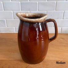 Load image into Gallery viewer, Vintage glossy brown drip glazed ceramic pitcher. Crafted by Hull Pottery, USA, 1960s. A beautiful piece to add to your home decor or art pottery collection!

In excellent condition, no chips/cracks/repairs. Maker&#39;s marks.

Measurements

Medium: 4 x 6 3/4 inches, 32 ounces

