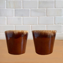 Load image into Gallery viewer, Pair of vintage glossy brown drip glaze mugs. Crafted by Hull Pottery, USA, 1960s. Enjoy any hot beverage in this fabulous retro oven-proof tableware!

In excellent condition, no chips/cracks/repairs. Maker&#39;s marks.

Measures 3 3/4x 3 1/2 inches

Capacity 8 ounces

