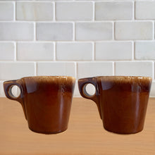 Load image into Gallery viewer, Pair of vintage glossy brown drip glaze mugs. Crafted by Hull Pottery, USA, 1960s. Enjoy any hot beverage in this fabulous retro oven-proof tableware!

In excellent condition, no chips/cracks/repairs. Maker&#39;s marks.

Measures 3 3/4x 3 1/2 inches

Capacity 8 ounces
