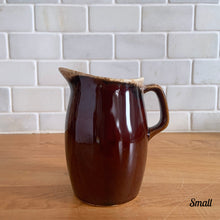 Load image into Gallery viewer, Vintage glossy brown drip glazed ceramic pitcher. Crafted by Hull Pottery, USA, 1960s. A beautiful piece to add to your home decor or art pottery collection!

In excellent condition, no chips/cracks/repairs. Maker&#39;s marks.

Measurements

Small: 2 3/4 x 4 1/2 inches, 8 ounces
