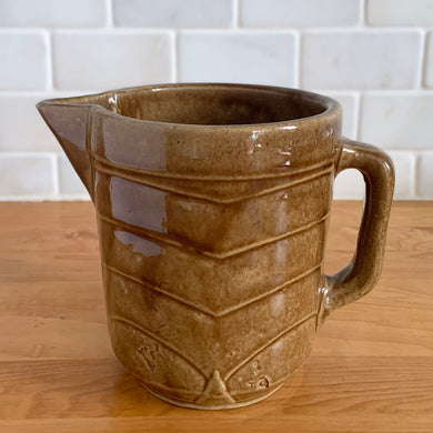 Vintage gloss brown stoneware pitcher with stacked chevron detail. Crafted by Monmouth Western Stoneware, USA, 1920s. Add this utilitarian piece to your farmhouse decor or art pottery collection!

In excellent vintage condition, no chips/cracks/repairs, age-related crazing. Unmarked.

Measures 4 1/2 x 5 inches