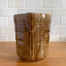 Load image into Gallery viewer, Vintage gloss brown stoneware pitcher with stacked chevron detail. Crafted by Monmouth Western Stoneware, USA, 1920s. Add this utilitarian piece to your farmhouse decor or art pottery collection!

In excellent vintage condition, no chips/cracks/repairs, age-related crazing. Unmarked.

Measures 4 1/2 x 5 inches
