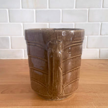 Load image into Gallery viewer, Vintage glossy light brown stoneware pitcher with stacked chevron detail. Crafted by Monmouth Western Stoneware, USA, 1920s. Add this utilitarian piece to your farmhouse decor or art pottery collection!

In excellent condition, no chips/cracks/repairs, age-related crazing. Unmarked.

Measures 4 1/2 x 5 inches
