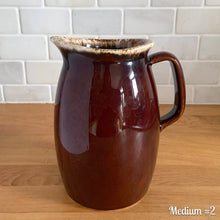 Load image into Gallery viewer, Vintage glossy brown drip glazed ceramic pitcher. Crafted by Hull Pottery, USA, 1960s. A beautiful piece to add to your home decor or art pottery collection!

In excellent condition, no chips/cracks/repairs. Maker&#39;s marks.

Measurements

Medium: 4 x 6 3/4 inches, 32 ounces

