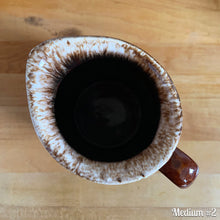 Load image into Gallery viewer, Vintage glossy brown drip glazed ceramic pitcher. Crafted by Hull Pottery, USA, 1960s. A beautiful piece to add to your home decor or art pottery collection!

In excellent condition, no chips/cracks/repairs. Maker&#39;s marks.

Measurements

Medium: 4 x 6 3/4 inches, 32 ounces
