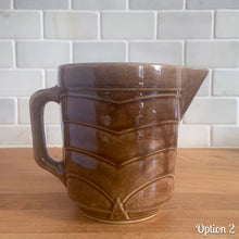 Load image into Gallery viewer, Vintage gloss brown stoneware pitcher with stacked chevron detail. Crafted by Monmouth Western Stoneware, USA, 1920s. Add this utilitarian piece to your farmhouse decor or art pottery collection!

In as found vintage condition, chip to the spout, no cracks/repairs, age-related crazing. Unmarked.

Measures 4 1/2 x 5 inches
