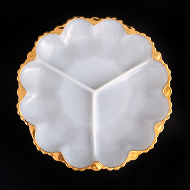 This classic vintage 896 3-part milk glass relish dish features a gold gilt sawtooth edge. Crafted by Anchor Hocking, USA, 1960s. This lovely relish dish would be perfect for serving your favourite pickled treats, candies or nuts. Elevate any occasion with this elegant platter!

In excellent condition, no chips.

Measures 10 x 1 1/4 inches