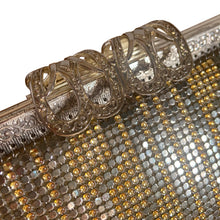 Load image into Gallery viewer, Stunning vintage silver and gold mesh evening bag with a geometric pattern, ornate patterned silver toned clasp, rope chain strap and pale gray lining with open pocket. Crafted by Elga, USA.

In good vintage condition, inside and out with wear to the mesh.

Measures 10 x 5 1/4 inches and with the strap 9 3/4 inches.
