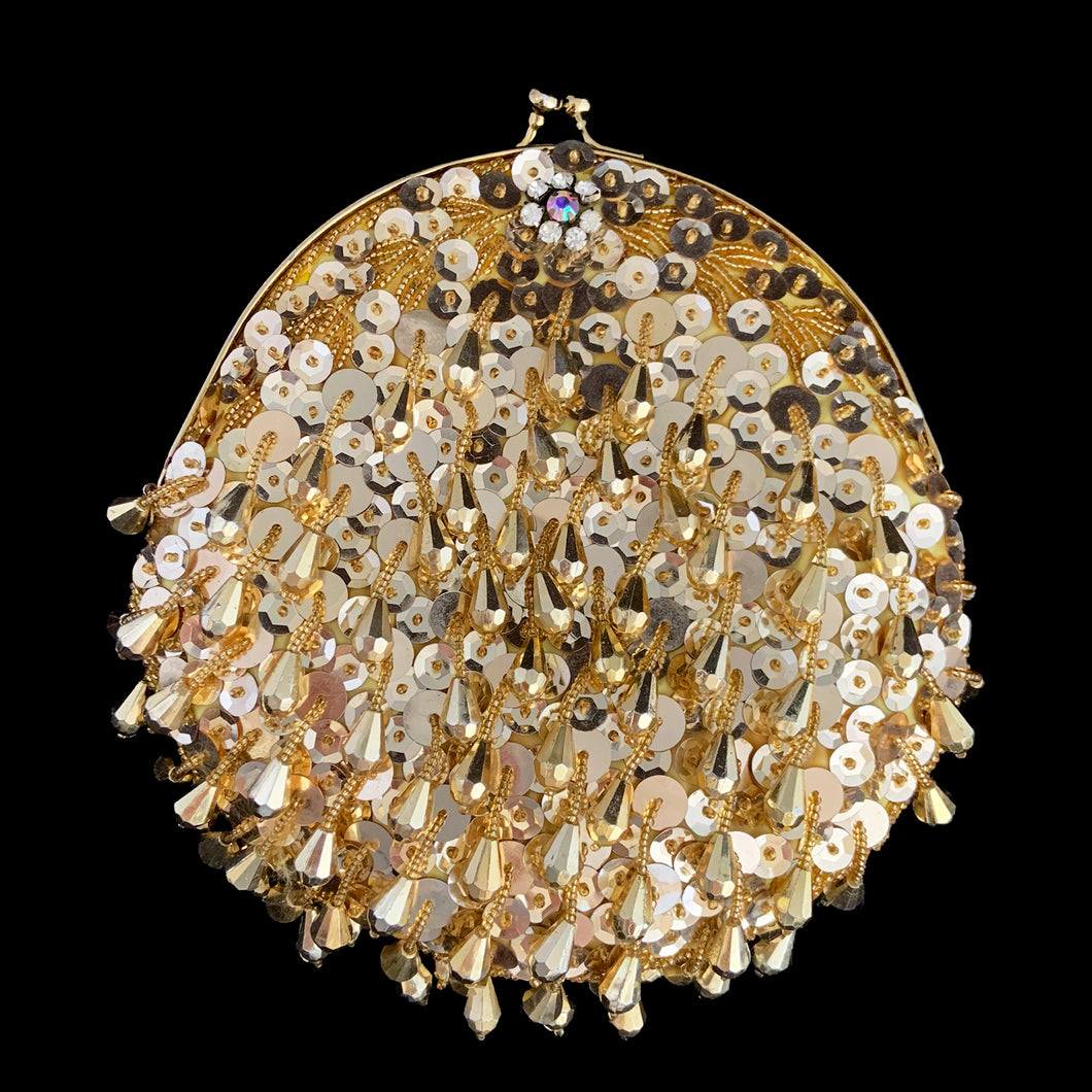 Stunning handmade vintage mid-century era evening bag adorned in bright gold teardrop and glass seed beads, sequins, topped with gold-toned hardware, rope chain handle and kiss closure. The interior is lined with yellow satin and has an open pocket. The bag is large enough for a small cell phone, credit cards/cash, compact/lipstick. Crafted by Kaiho, Macau, 1960s. An absolutely stunning piece that would make an a versatile fashion accessory which may be worn as a shoulder bag, a crossbody bag or a clutch.