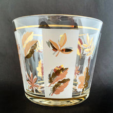 Load image into Gallery viewer, This vintage mid-century Golden Foliage flared glass ice bucket is decorated with a variety of gold leaves against alternating frosted and clear panels with gold rims. Crafted by Libbey Glass, USA, 1953 - 1978. This piece holds a good amount of ice cubes to keep your cocktails cold. Your bar cart has never looked better!

In great vintage condition, no chips, minor wear to the gold rim, but otherwise bright and shiny!

Measures 5 5/8 x 4 3/4 inches
