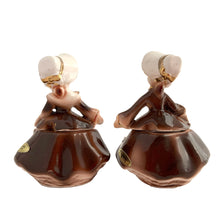 Load image into Gallery viewer, Vintage hand painted Golden Girl ceramic condiment set with tray. Enesco, Japan, 1960s. Add this pretty set to your collection!

In excellent condition, no chips/cracks/repairs.

Each girl measures 2 1/2 x 1 7/8 x 3 1/2 inches

Tray measures 6 1/4 x 2 1/8 inches
