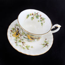 Load image into Gallery viewer, This vintage bone china footed teacup and saucer is so sweet! Both the cup and saucer are decorate with the &quot;Goldfinch&quot; pattern from the Woodland Series. Each piece has a lovely scalloped edge featuring a hand painted goldfinch bird with spruce boughs, trimmed with gold gilt. Produced by Royal Albert, England, circa 1917 - 1927.  In excellent condition, free from chips, cracks and repairs. Maker&#39;s marks are on the bottom.   Teacup measures 3 3/8 x 2 3/4 inches  | Saucer measures 5 1/4 inches
