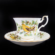 Load image into Gallery viewer, This vintage bone china footed teacup and saucer is so sweet! Both the cup and saucer are decorate with the &quot;Goldfinch&quot; pattern from the Woodland Series. Each piece has a lovely scalloped edge featuring a hand painted goldfinch bird with spruce boughs, trimmed with gold gilt. Produced by Royal Albert, England, circa 1917 - 1927.  In excellent condition, free from chips, cracks and repairs. Maker&#39;s marks are on the bottom.   Teacup measures 3 3/8 x 2 3/4 inches  | Saucer measures 5 1/4 inches
