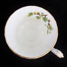 Load image into Gallery viewer, This vintage bone china footed teacup and saucer is so sweet! Both the cup and saucer are decorate with the &quot;Goldfinch&quot; pattern from the Woodland Series. Each piece has a lovely scalloped edge featuring a hand painted goldfinch bird with spruce boughs, trimmed with gold gilt. Produced by Royal Albert, England, circa 1917 - 1927.  In excellent condition, free from chips, cracks and repairs. Maker&#39;s marks are on the bottom.   Teacup measures 3 3/8 x 2 3/4 inches  | Saucer measures 5 1/4 inches
